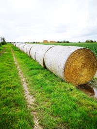 Hay bales on field against sky