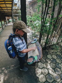 Rear view of boy wearing hat on footpath