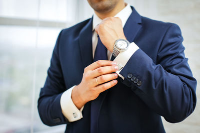 Midsection of businessman cuff link shirt sleeve at home