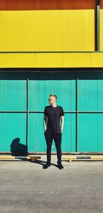 Man standing on road against wall