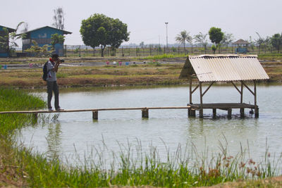 Men on shore against sky during rainy season