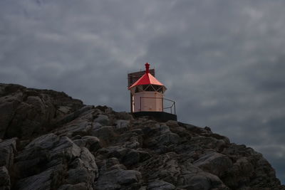 Lighthouse by sea against sky