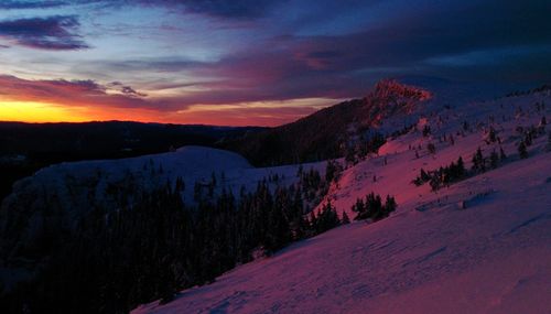 Scenic view of snowcapped mountains against sky during sunset