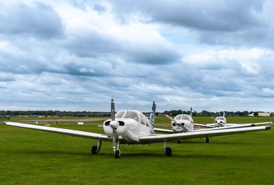 Airplane on airport runway against sky