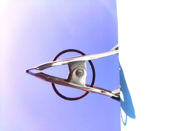 Low angle view of eyeglasses against clear blue sky