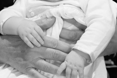 Close-up of mother holding baby hand