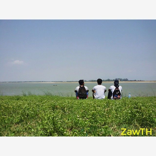 men, lifestyles, leisure activity, togetherness, grass, person, field, sitting, rear view, bonding, sky, clear sky, landscape, copy space, friendship, nature, transfer print