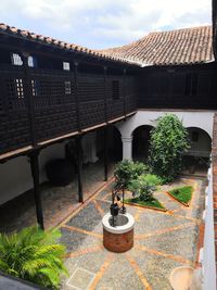 Potted plants and building in yard against sky