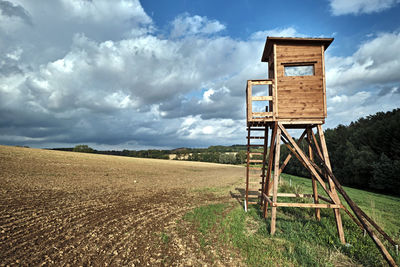 Lifeguard hut on field against sky