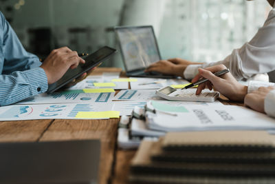 Midsection of business colleagues working on table
