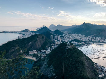 Scenic view of river by mountains against sky