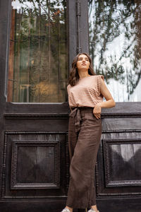 Full length of young woman standing against trees