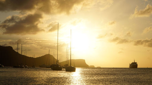 Silhouette sailboat sailing on sea against sky during sunset