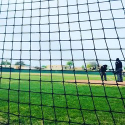 People playing on field against sky