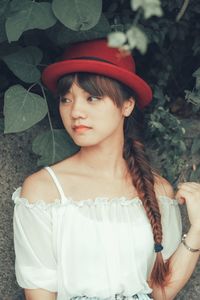 Thoughtful young woman in hat looking away