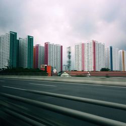 View of city street and buildings against sky