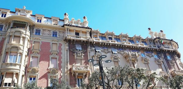 Low angle view of buildings against clear blue sky