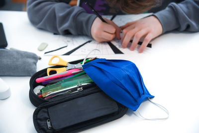 Midsection of boy studying at home