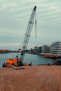 Cranes at construction site against sky