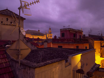 Buildings in city against cloudy sky