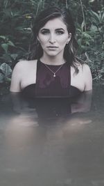 Portrait of smiling young woman against trees