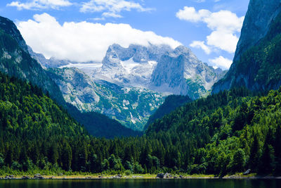 Scenic view of mountains and lake against cloudy sky