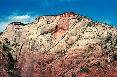 Scenic view of rocky mountains against blue sky on sunny day