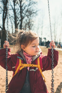 Close-up of girl on swing at playground