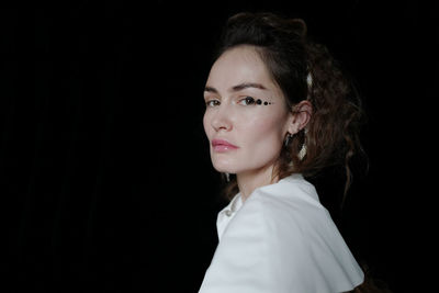 Portrait of a beautiful young woman over black background