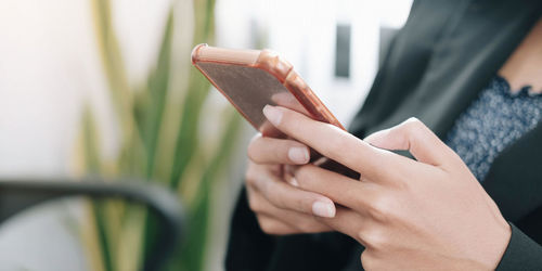 Close-up of woman using mobile phone outdoors