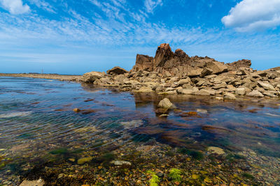 Rock formation in sea against sky