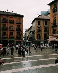 People on street in city against sky