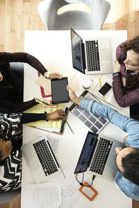 Overhead view of business people discussing on table in creative office