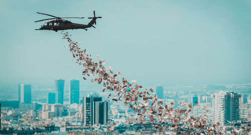 Low angle view of airplane flying against buildings in city