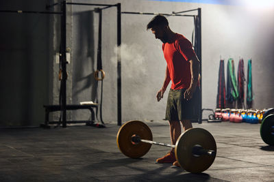 Full length of man holding camera at home