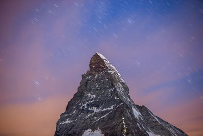 Low angle view of rock formation against sky at night