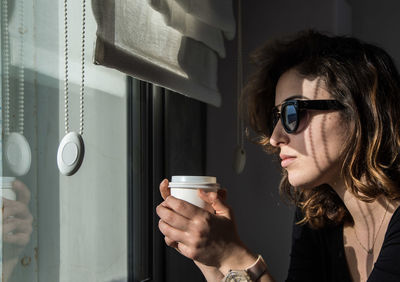 Portrait of woman looking through window