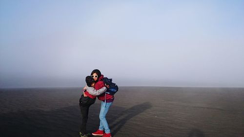Women on landscape against sky during winter