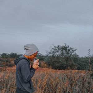 Man standing on field against sky