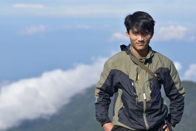 Portrait of young man standing against sky