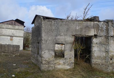 Abandoned house on field against sky