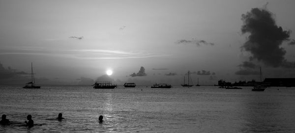 View of boats in sea at sunset