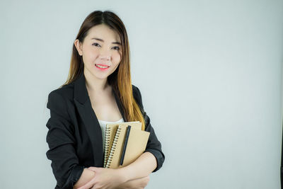 Portrait of a smiling young woman over white background