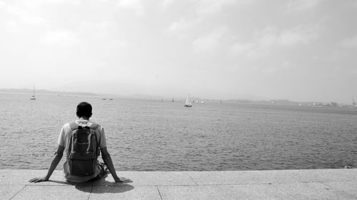 Woman standing by sea against sky