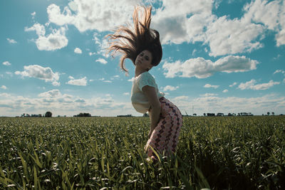 Side view of woman sitting on field