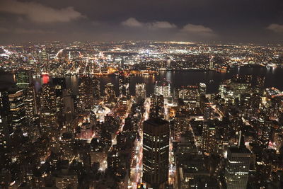 High angle view of illuminated cityscape against sky at night