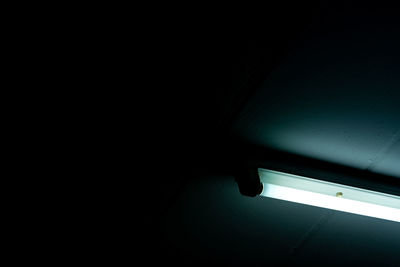 Low angle view of illuminated lamp in darkroom