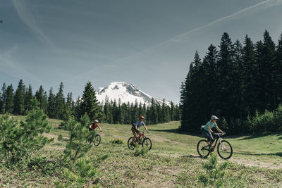 Threee women bike on a trail near mt. hood in oregon.