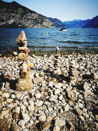 Stack of pebbles by sea against sky