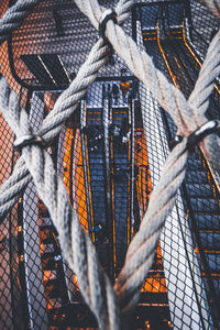 Low angle view of ropes hanging on metal fence